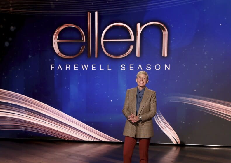 A talk show host appears onstage in front of a screen that says 'Ellen Farewel Season'