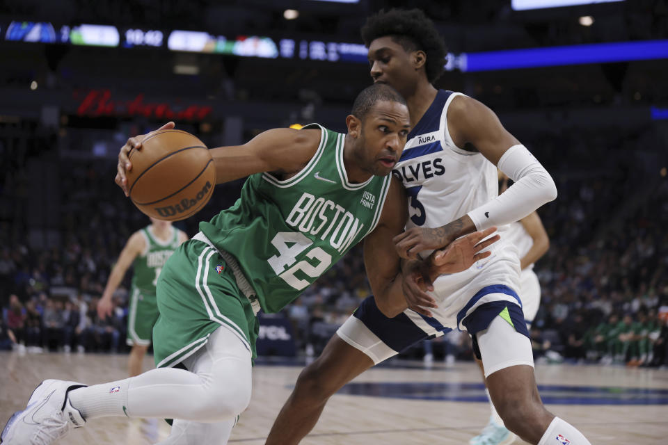 Boston Celtics center Al Horford (42) drives the ball around Minnesota Timberwolves forward Jaden McDaniels (3) during the first half of an NBA basketball game Monday, Dec. 27, 2021, in Minneapolis. (AP Photo/Stacy Bengs)