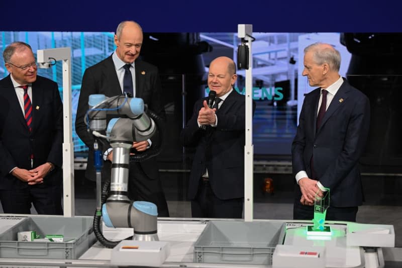 (L-R) Stephan Weil, Prime Minister of Lower Saxony, Roland Busch, CEO of Siemens, German Chancellor Olaf Scholz, and Prime Minister of Norway Jonas Gahr Store interacte with a robotic arm at the Hannover Fair 2024. Julian Stratenschulte/dpa