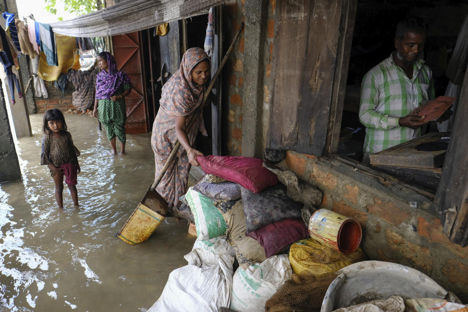 People inspect the damaged belongings in their homes as flood water levels recede slowly in Sylhet, Bangladesh, Wednesday, June 22, 2022. (AP Photo/Mahmud Hossain Opu)