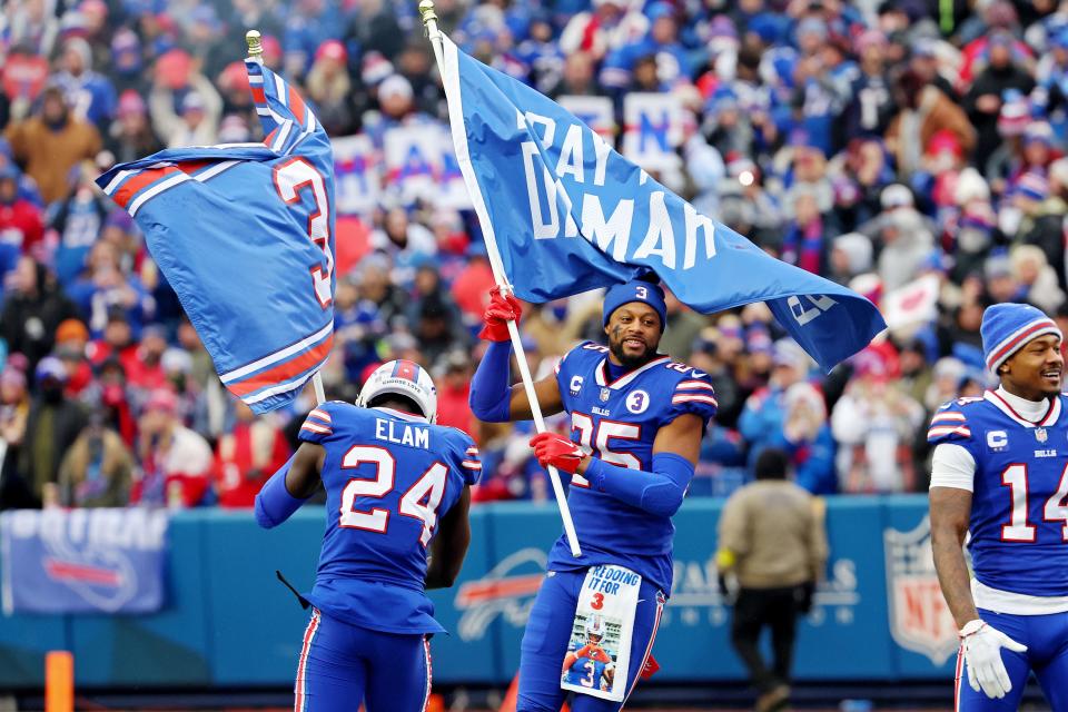 Buffalo Bills players waved flags supporting Damar Hamlin during game against New England Patriots on Sunday.