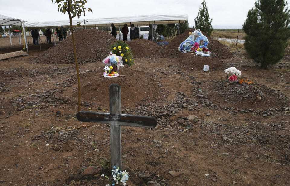 Freshly dug graves, top of photo, are prepared for Rhonita Miller, 30, and four of her young children Krystal and Howard, and twins Titus and Tiana, who were murdered by drug cartel gunmen, before their burial at a cemetery in LeBaron, Chihuahua state, Mexico, Friday, Nov. 8, 2019. A total of three women and six of their children, from the extended LeBaron family, were gunned down in a cartel ambush while traveling along Mexico's Chihuahua and Sonora state border on Monday. The graves in the foreground are not related to the burial of the Miller family. (AP Photo/Marco Ugarte)