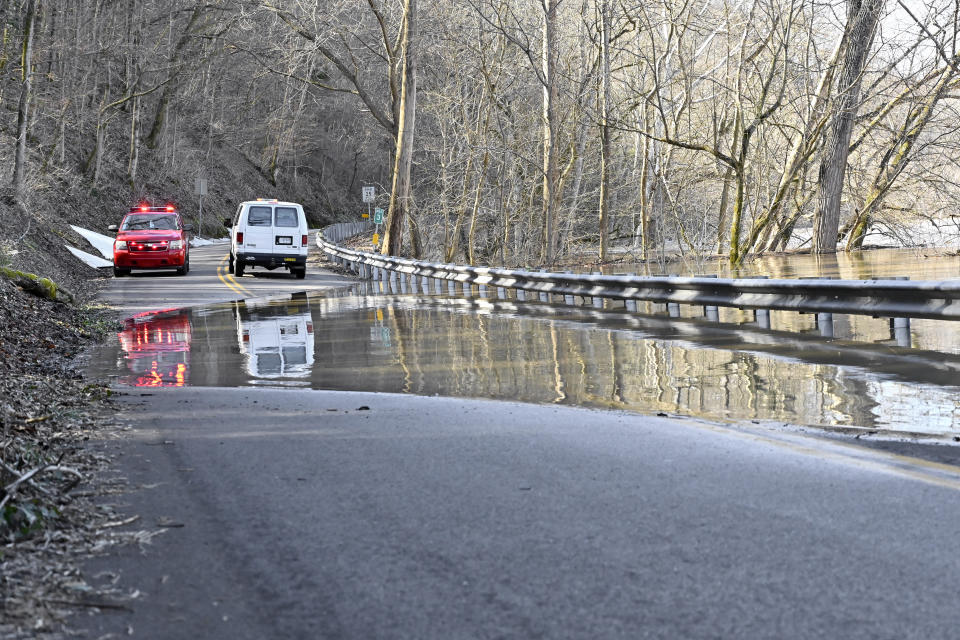 Road crews and members of the Frankfort, Ky., fire department block traffic from traveling on Big Eddy Road as the Kentucky River washes over the roadway in Frankfort, Ky., Tuesday, March 2, 2021. (AP Photo/Timothy D. Easley)