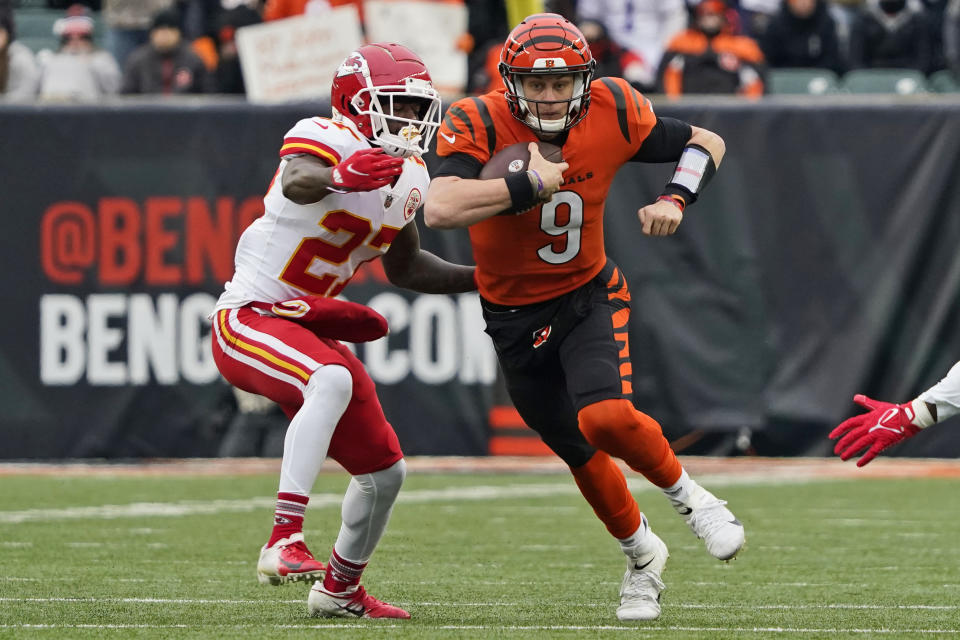 Cincinnati Bengals quarterback Joe Burrow (9) scrambles against Kansas City Chiefs cornerback Rashad Fenton (27) during the first half of an NFL football game, Sunday, Jan. 2, 2022, in Cincinnati. (AP Photo/Jeff Dean)