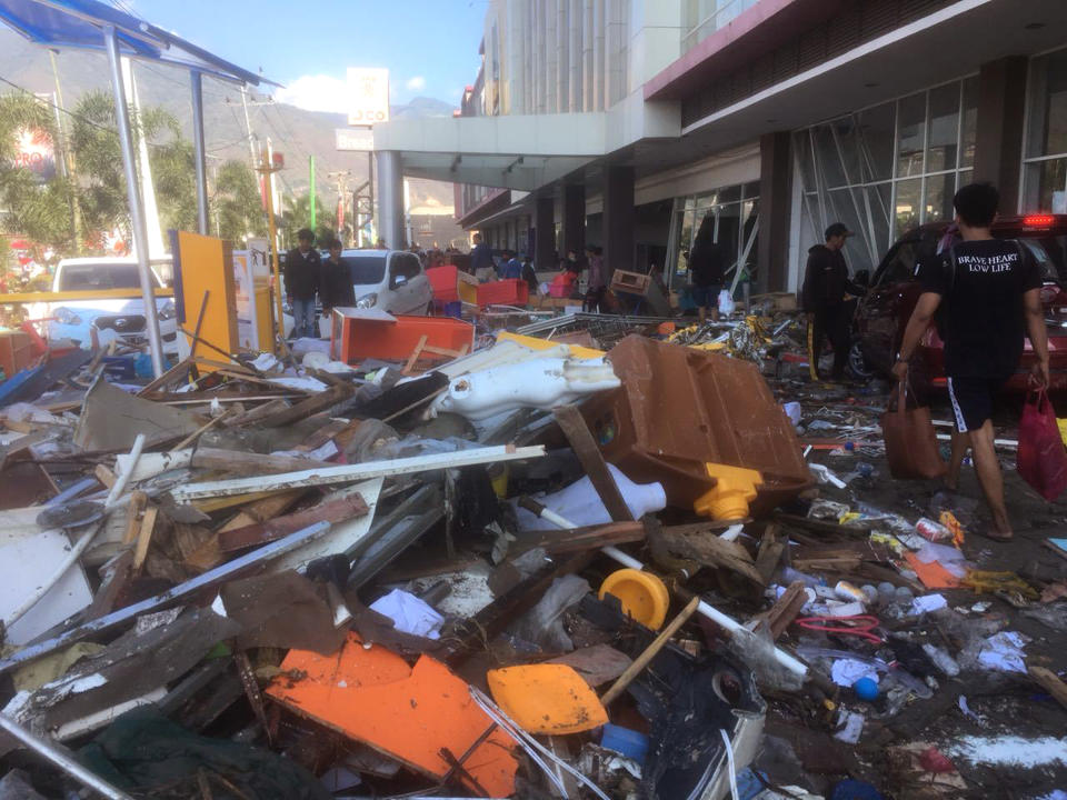 People survey the damage following earthquakes and tsunami in Palu, Central Sulawesi, Indonesia, Sunday, Sept. 30, 2018. A tsunami swept away buildings and killed large number of people on the Indonesian island of Sulawesi, dumping victims caught in its relentless path across a devastated landscape that rescuers were struggling to reach Saturday, hindered by damaged roads and broken communications. (AP Photo/Tatan Syuflana)