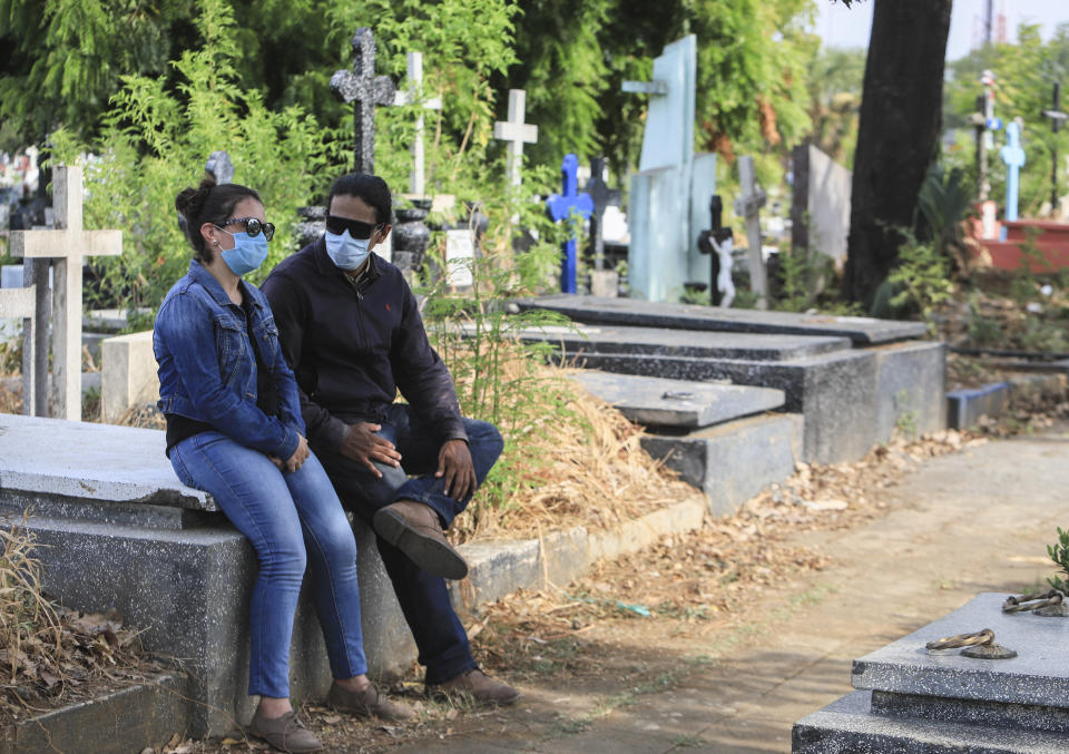 A couple wear masks as they attend a funeral at the Central cemetery of Managua, Nicaragua, Monday, May 11, 2020. President Daniel Ortega's government has stood out for its refusal to impose measures to halt the new coronavirus for more than two months since the disease was first diagnosed in Nicaragua. Now, doctors and family members of apparent victims say, the government has gone from denying the disease's presence in the country to actively trying to conceal its spread. (AP Photo/Alfredo Zuniga)