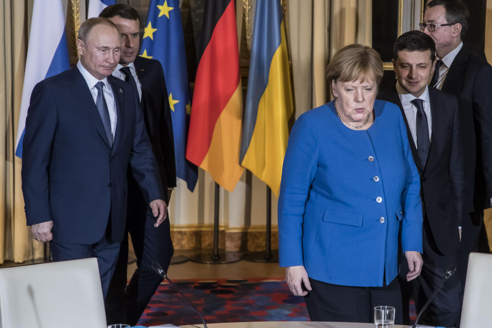 Russian President Vladimir Putin, left, French President Emmanuel Macron, second left, Ukrainian President Volodymyr Zelenskiy, right, and German Chancellor Angela Merkel arrive at a working session at the Elysee Palace Monday, Dec. 9, 2019 in Paris. Russian President Vladimir Putin and Ukraine's president are meeting for the first time at a summit in Paris to find a way to end the five years of fighting in eastern Ukraine. (Christophe Petit Tesson/Pool via AP)