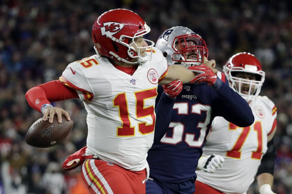 Kansas City Chiefs quarterback Patrick Mahomes grabs the face mask of New England Patriots linebacker Kyle Van Noy, right, as he rolls out to pass in the second half of an NFL football game, Sunday, Dec. 8, 2019, in Foxborough, Mass. Mahomes was penalized on the play. (AP Photo/Elise Amendola)