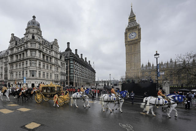 El rey Carlos III de Gran Bretaña y Camila, la reina consorte, se dirigen en el Carruaje Jubileo de Diamante frente al Palacio de Westminster a su ceremonia de coronación en Londres el sábado 6 de mayo de 2023. (Foto AP/Markus Schreiber)