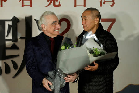 U.S. director Martin Scorsese smiles as he receiving flowers from Taiwanese director Hou Hsiao-Hsien (R) during the premiere of "Silence", in Taipei, Taiwan January 19, 2017. REUTERS/Tyrone Siu