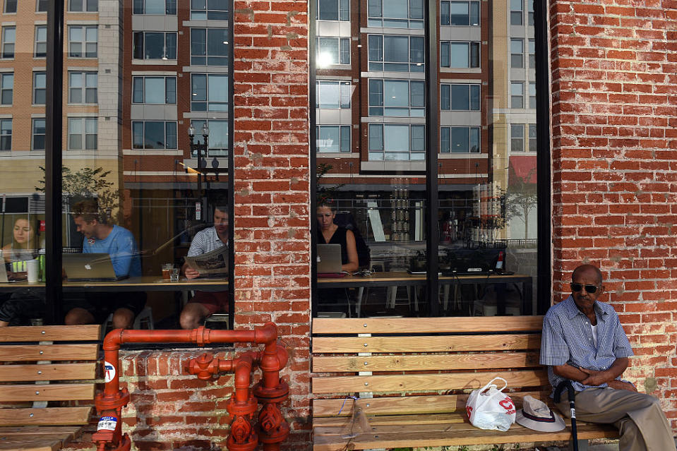 New apartments are reflected in the window glass of a trendy cafe in Washington's Shaw neighborhood.