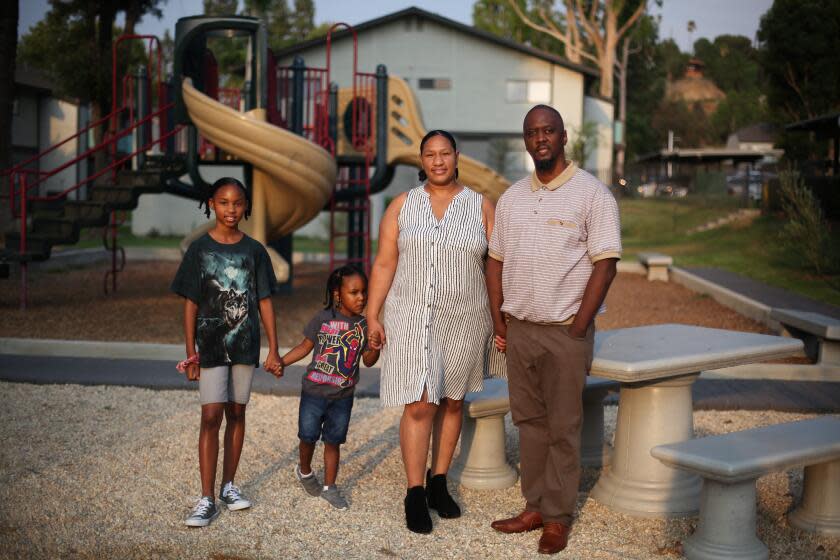 SAN BERNARDINO, CA - AUGUST 21: Terrance Stewart Jr., right, stands for a portrait with his children Taylor, 10, and Terrance the 3rd, 4, and wife Tiffane, left to right, in the playground area of the apartment complex where they have lived since 2018 in Colton on Friday, Aug. 21, 2020 in San Bernardino, CA. Due to crime-free housing policies, ever since Stewart was released from prison on a felony drug charge in 2005 he has struggled to find housing for he and his family. Stewart reflected, "that thing I did in my twenties is not who I am. I bring something positive for the community. (Dania Maxwell / Los Angeles Times)