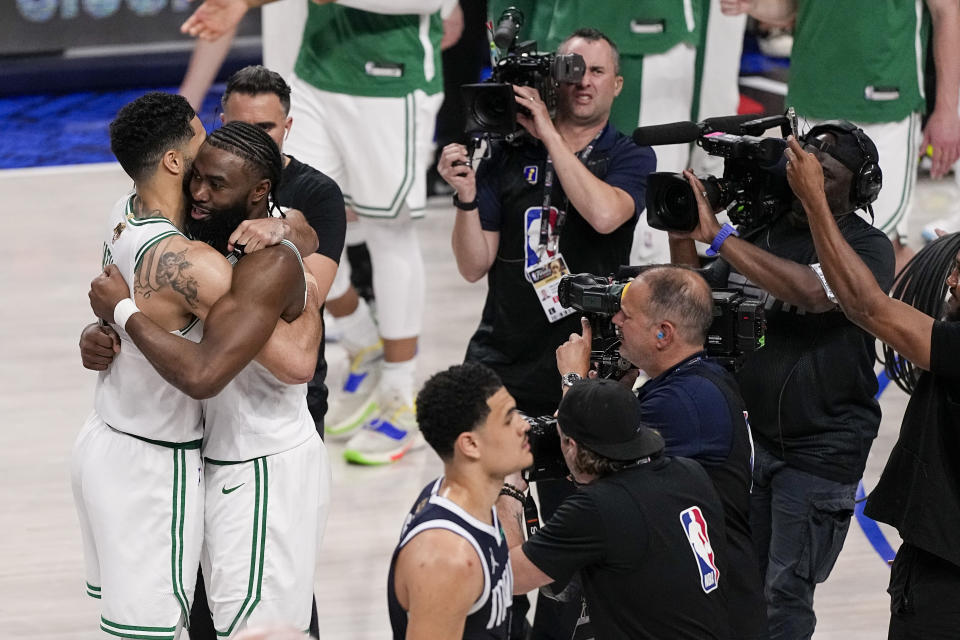 Boston Celtics forward Jayson Tatum, left, is hugged by guard Jaylen Brown after they defeated the Dallas Mavericks 106-99 in Game 3 of the NBA basketball finals, Wednesday, June 12, 2024, in Dallas. (AP Photo/Tony Gutierrez)