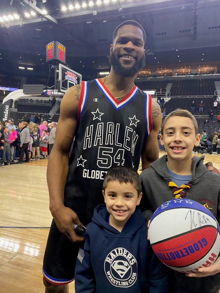 Brayden Cabral, seen holding a basketball, and brother Chace at a Harlem Globetrotters game on Feb. 10.