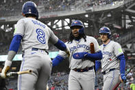 Toronto Blue Jays' Vladimir Guerrero Jr., center, is greeted by Cavan Biggio (8) and Danny Jansen, right, after scoring on a fielder's choice hit into by Daniel Vogelbach during the first inning of a baseball game against the Washington Nationals, Saturday, May 4, 2024, in Washington. (AP Photo/Nick Wass)