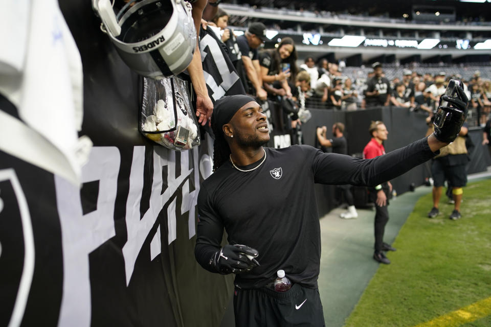 Las Vegas Raiders wide receiver Davante Adams takes a selfie with fans before an NFL preseason football game against the New England Patriots, Friday, Aug. 26, 2022, in Las Vegas. (AP Photo/John Locher)