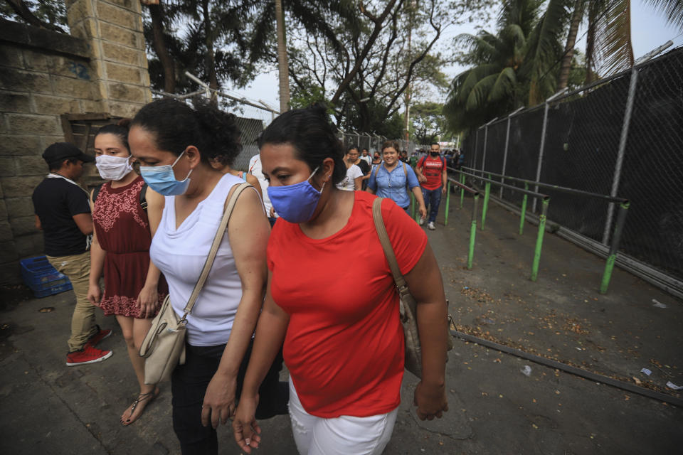 Workers wear masks as a protection against the spread of the new coronavirus as they leave from a day's work in Managua, Nicaragua, Monday, May 11, 2020. President Daniel Ortega's government has stood out for its refusal to impose measures to halt the new coronavirus for more than two months since the disease was first diagnosed in Nicaragua. Now, doctors and family members of apparent victims say, the government has gone from denying the disease's presence in the country to actively trying to conceal its spread. (AP Photo/Alfredo Zuniga)