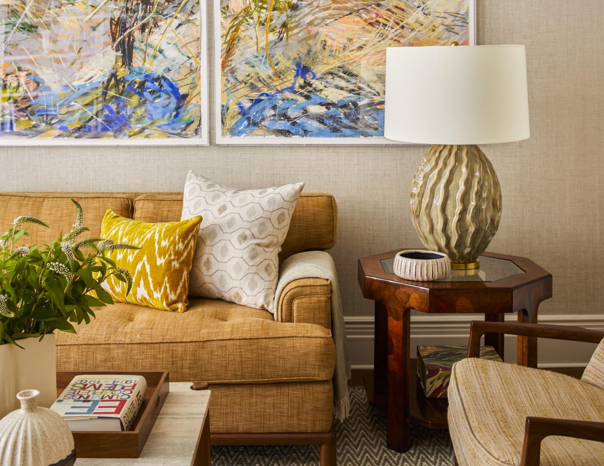  A living room with art on the walls and colorful decor. 