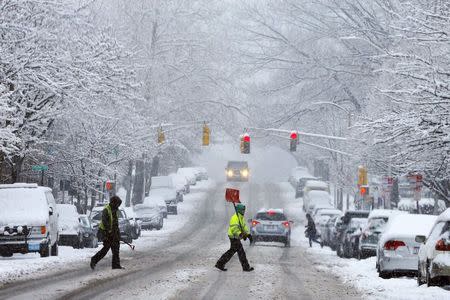 A snow shoveler crosses a street during a winter snowstorm in Cambridge, Massachusetts January 24, 2015. REUTERS/Brian Snyder