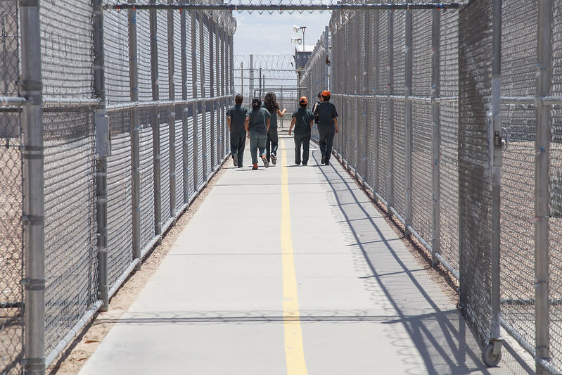 Immigrant detainees surrounded by fences in an ICE facility