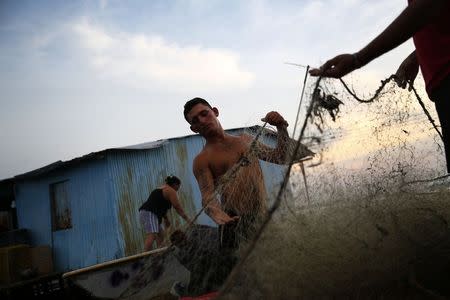 Fishermen prepare their nets in the village of Ologa in the western state of Zulia October 23, 2014. REUTERS/Jorge Silva