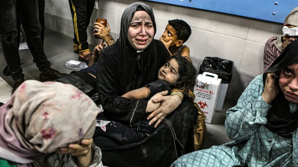 Women and children wait for treatment at Al-Shifa Hospital on Tuesday night. - Abed Khaled/AP