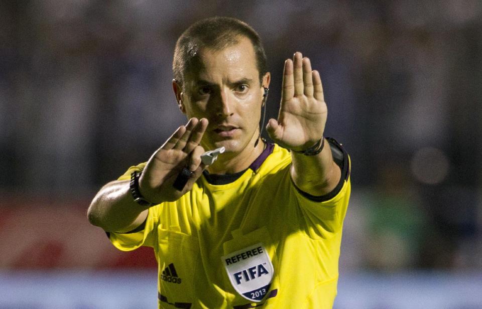 FILE - In this Tuesday Sept. 10, 2013 file photo, referee Mark Geiger signals a call at a 2014 World Cup qualifier soccer match between Honduras and Panama in Tegucigalpa, Honduras. Mark Geiger aims to become the first American referee to advance from the group stage in the World Cup in Brazil. (AP Photo/Moises Castillo, File)