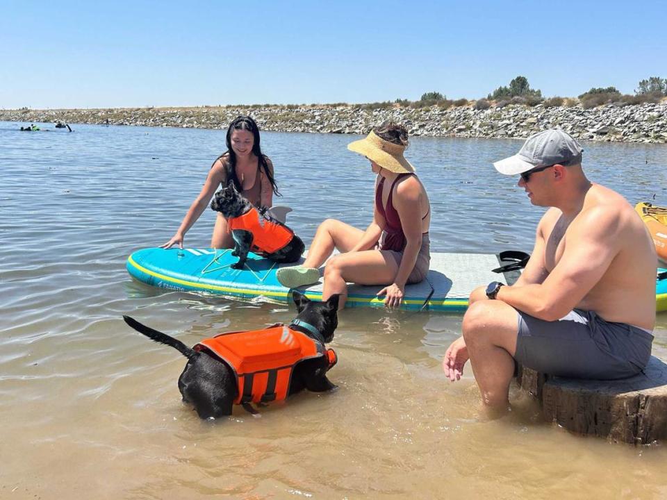 Zach Christensen, accompanied by his wife, Olivia, and colleague Rachel Conshue, left, take their pets out to enjoy the cool waters of Folsom Lake in July 2023.