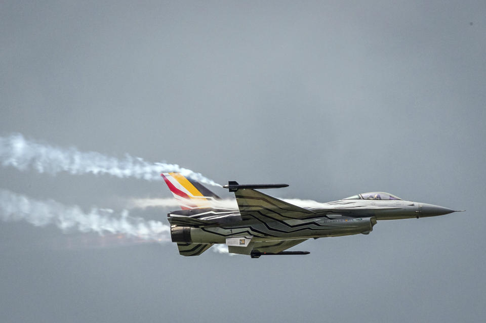 FILE - In this Wednesday, May 18, 2016 file photo, a Belgian F16 fighter jet flies over Florennes Military Airbase, in Florennes, Belgium. A Belgian F-16 fighter jet crashed Thursday, Sept. 19, 2019 on a road in western France and one of its pilots is hanging from a high-voltage electricity line after his parachute got caught, according to French authorities. (AP Photo/Geert Vanden Wijngaert, File)
