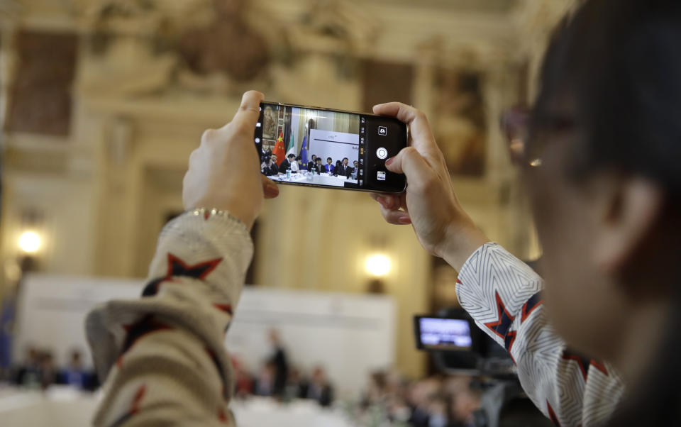 A Chinese journalist takes pictures on the occasion of the Italy-China Financial forum, at Palazzo Marino town hall, in Milan, Italy, Wednesday, July 10, 2019. (AP Photo/Luca Bruno)