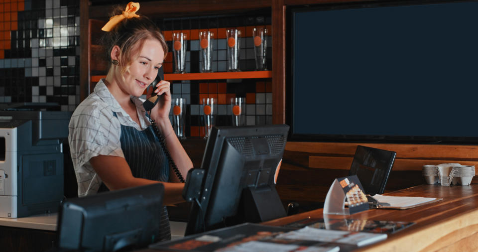 person answering the phone behind a counter