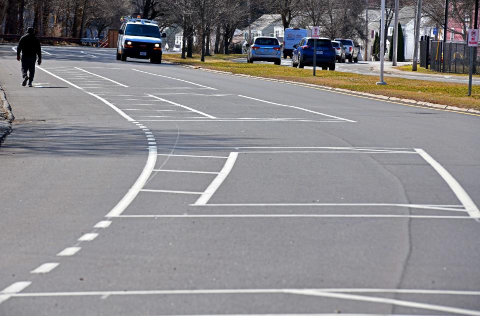 A pedestrian walks in t he bicycle lane on Mill Street