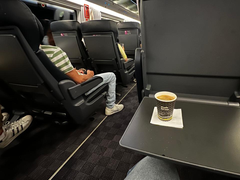 Seat of a train with coffee.