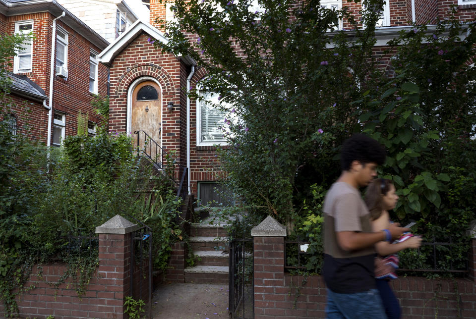 People pass by the residence of Nazi war crimes suspect Jakiw Palij on Tuesday, Aug. 21, 2018, in the Queens borough of New York. Palij, the last Nazi war crimes suspect facing deportation from the U.S., was taken from his home and spirited early Tuesday morning to Germany, the White House said. (AP Photo/Craig Ruttle)