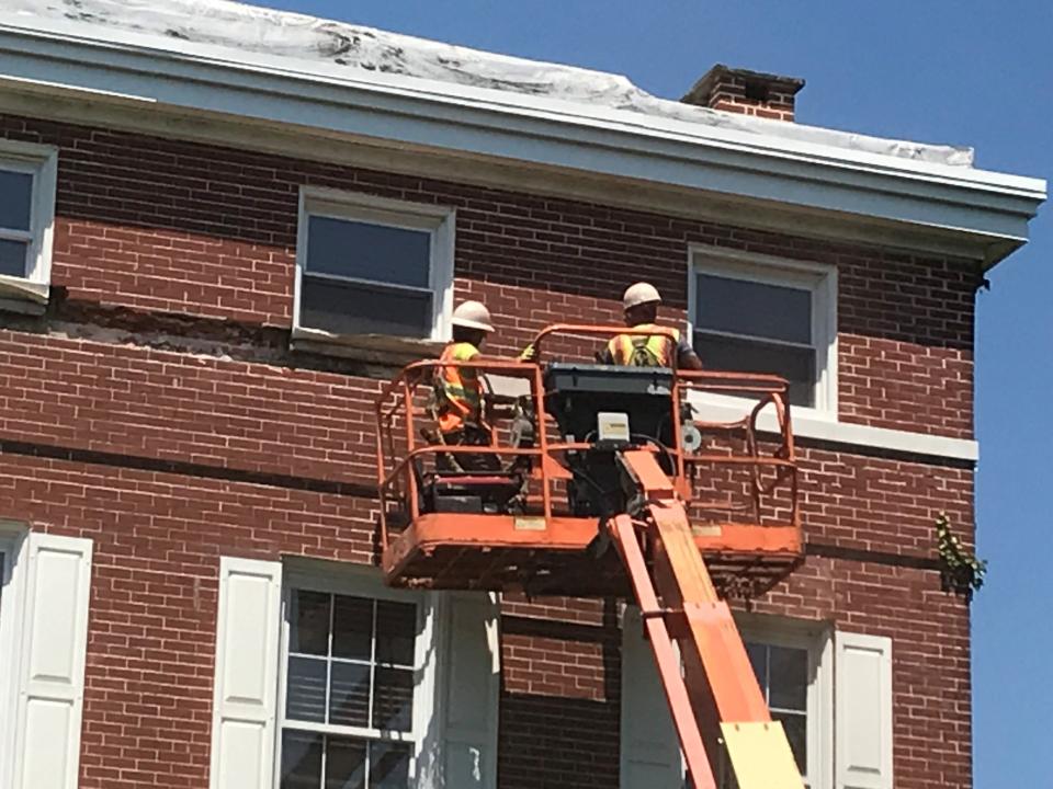 Workers drill and chisel out  trim on the third story of the historic Ephraim Tomlinson Mansion in Stratford.  The former home and school, listed on The National Register of Historic Places, is to be torn down for senior housing.