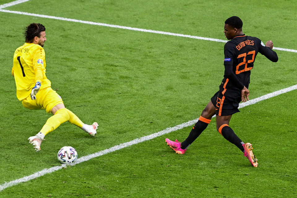 CORRECTS PHOTOGRAPHER NAME - Denzel Dumfries of the Netherlands, right, kicks the ball next to North Macedonia's goalkeeper Stole Dimitrievski during the Euro 2020 soccer championship group C match between North Macedonia and The Netherlands at the Johan Cruyff ArenA in Amsterdam, Netherlands, Monday, June 21, 2021. (Olaf Kraak, Pool via AP)