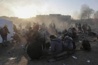 Refugees try to stay warm after fleeing the Russian invasion of Ukraine, at the Medyka border crossing in Poland, Tuesday, March 1, 2022. All day long, as trains and buses bring people fleeing Ukraine to the safety of Polish border towns, they carry not just Ukrainian fleeing a homeland under attack but large numbers of other citizens who had made Ukraine their home and whose fates too are now uncertain. (AP Photo/Visar Kryeziu)