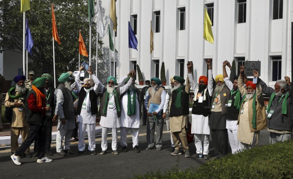 Representatives of various farmers organizations hold hands before the media as they arrive for talks with the government representatives in New Delhi, India, Thursday, Dec.3, 2020. Tens and thousands of farmers have descended upon the borders of New Delhi to protest new farming laws that they say will open them to corporate exploitation. (AP Photo/Manish Swarup)