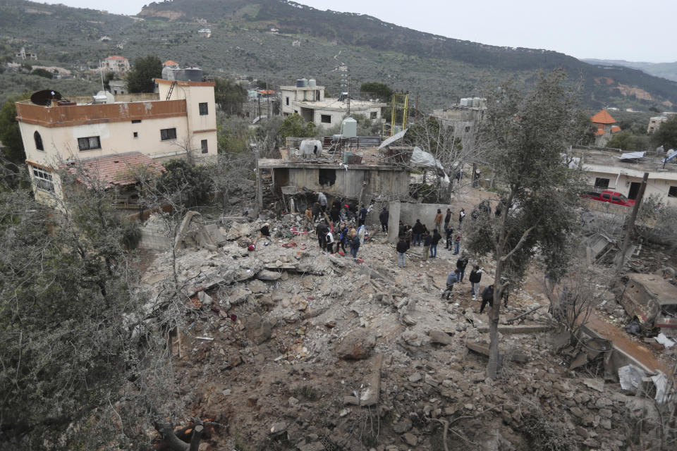 People gather on the rubble of a paramedic center that was destroyed by an Israeli airstrike early Wednesday in Hebbariye village, south Lebanon, Wednesday, March 27, 2024. The Israeli airstrike on a paramedic center linked to a Lebanese Sunni Muslim group killed several people of its members. The strike was one of the deadliest single attacks since violence erupted along the Lebanon-Israel border more than five months ago. (AP Photo/Mohammed Zaatari)