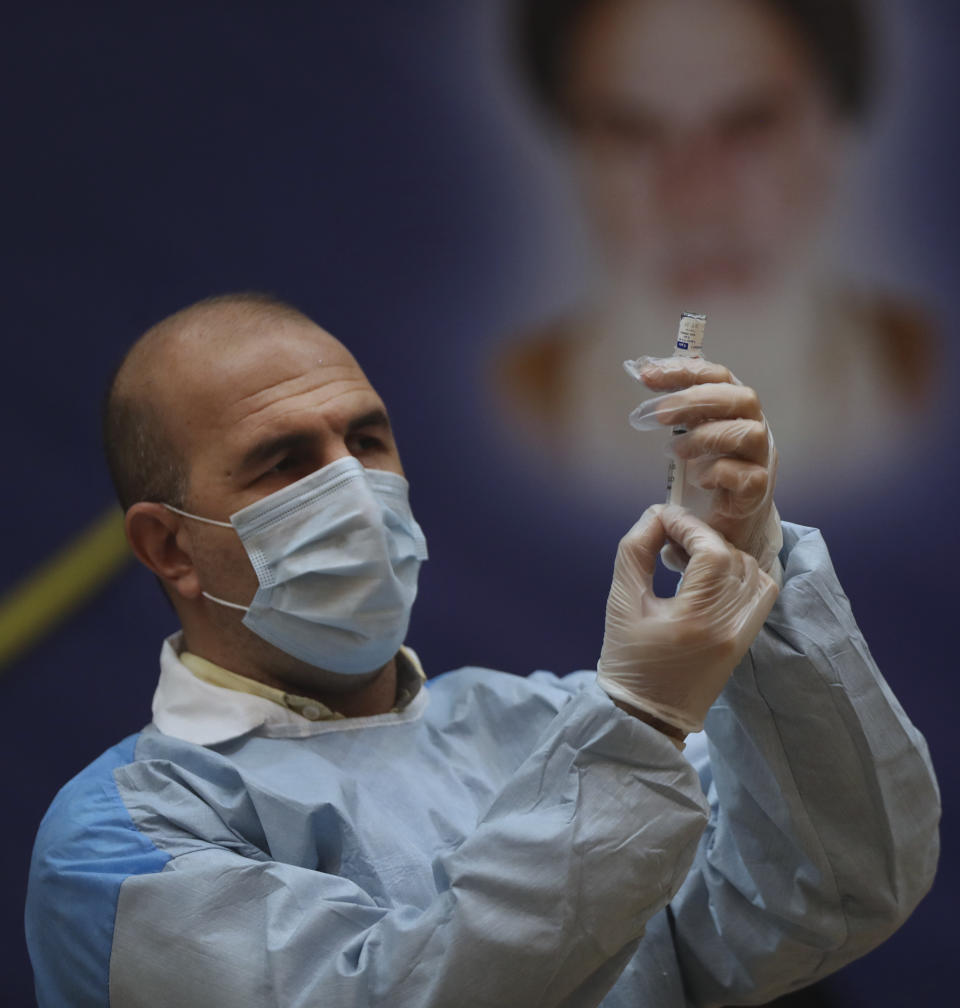 A medic prepares a shot of the Russian Sputnik V coronavirus vaccine in a staged event at Imam Khomeini Hospital in Tehran, Iran, Tuesday, Feb. 9, 2021. Iran on Tuesday launched a coronavirus inoculation campaign among healthcare professionals with recently delivered Russian Sputnik V vaccines as the country struggles to stem the worst outbreak of the pandemic in the Middle East with its death toll nearing 59,000. (AP Photo/Vahid Salemi)