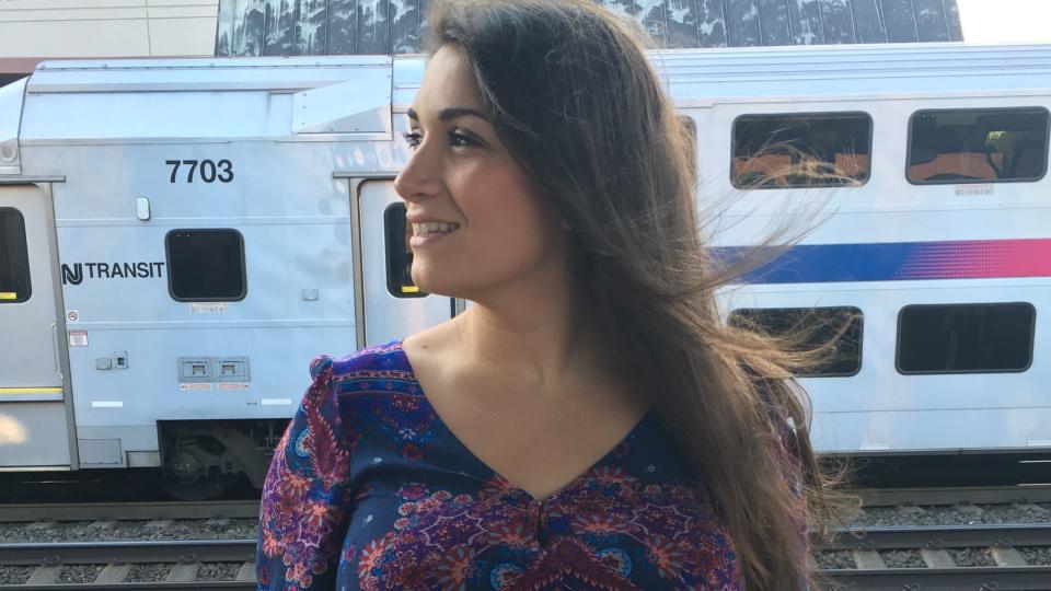 the author standing in front of a train with her long hair blowing behind her