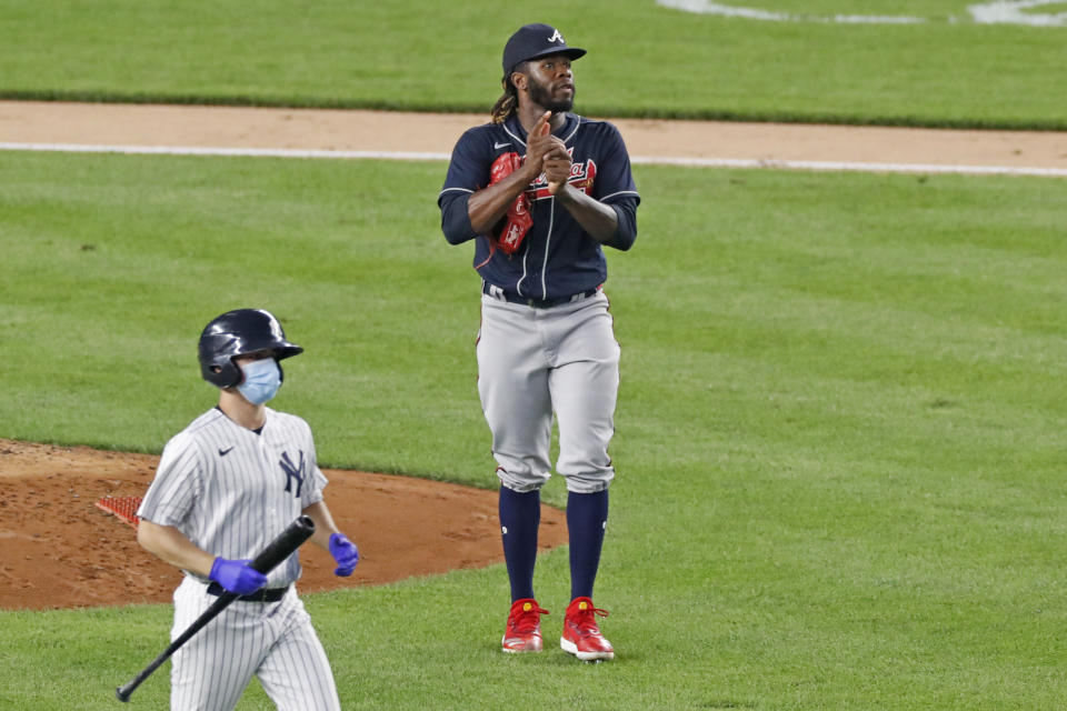 Atlanta Braves starting pitcher Touki Toussaint, right, watches a replay of Mike Ford's third inning, two-run double as a bat boy comes to collect Ford's batting gear from him at second base as seen from right field during a baseball game against the New York Yankees, Tuesday, Aug. 11, 2020, in New York. (AP Photo/Kathy Willens)