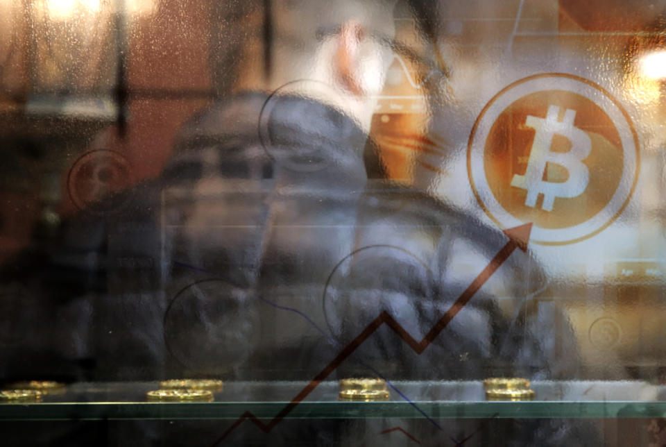 A man uses a Bitcoin ATM in Hong Kong, Friday, Dec. 8, 2017. Bitcoin is the world's most popular virtual currency. Such currencies are not tied to a bank or government and allow users to spend money anonymously. They are basically lines of computer code that are digitally signed each time they are traded. (AP Photo/Kin Cheung)