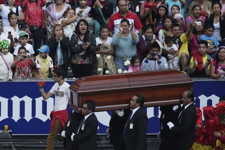 People applaud as pallbearers carry the coffin with the remains of late screenwriter Roberto Gomez Bolanos, after a mass to honour him at the Azteca stadium in Mexico City November 30, 2014. REUTERS/Tomas Bravo