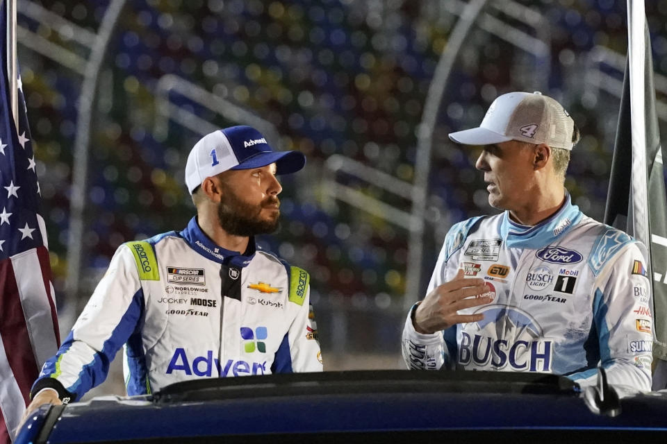 Ross Chastain, left, and Kevin Harvick ride before fans during driver introductions before the first of two qualifying auto races for the NASCAR Daytona 500 at Daytona International Speedway, Thursday, Feb. 16, 2023, in Daytona Beach, Fla. (AP Photo/John Raoux)