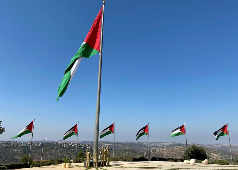 A general view shows Palestinian flags and a golden sculpture on a hilltop in Rawabi in the Israeli-occupied West Bank