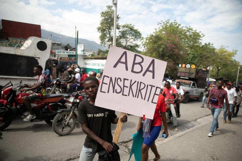 A man carries a sign that reads in Creole “Down with insecurity,” during a protest against increasing violence in Port-au-Prince, Haiti, Tuesday, March 29, 2022. The protest coincides with the 35th anniversary of Haiti’s 1987 Constitution and follows other protests and strikes in recent weeks in the middle of a spike in gang-related kidnappings.