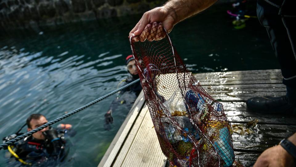 Ein Taucher hält ein Netz mit Abfällen, die er im baskischen Dorf Bermeo aus dem Meer entzogen hat. (Archivbild)
