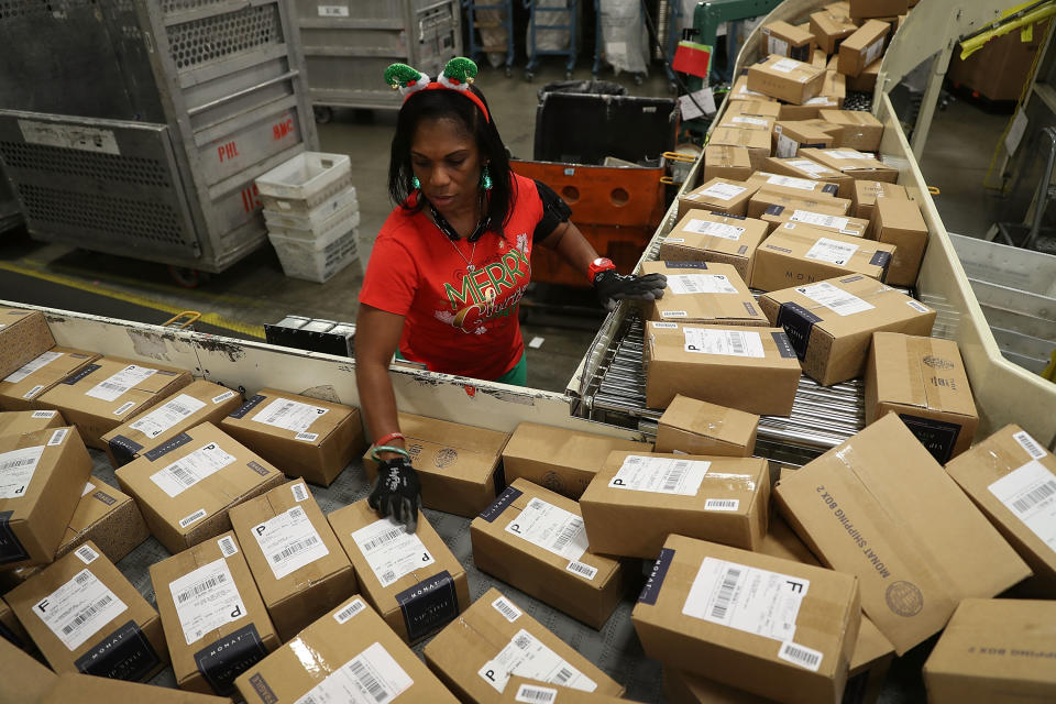 U.S. Postal service mail handler Barbara Lynn sorts boxes at the U.S. Postal service's Royal Palm Processing and Distribution Center on December 4, 2017, in Opa Locka, Florida. (Photo by Joe Raedle/Getty Images)