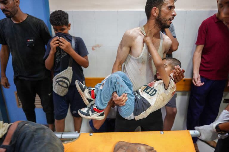 Un hombre carga a un niño herido durante el bombardeo israelí en el hospital Nasser en Khan Younis, en el sur de la Franja de Gaza, el 9 de julio de 2024. (Bashar TALEB / AFP)